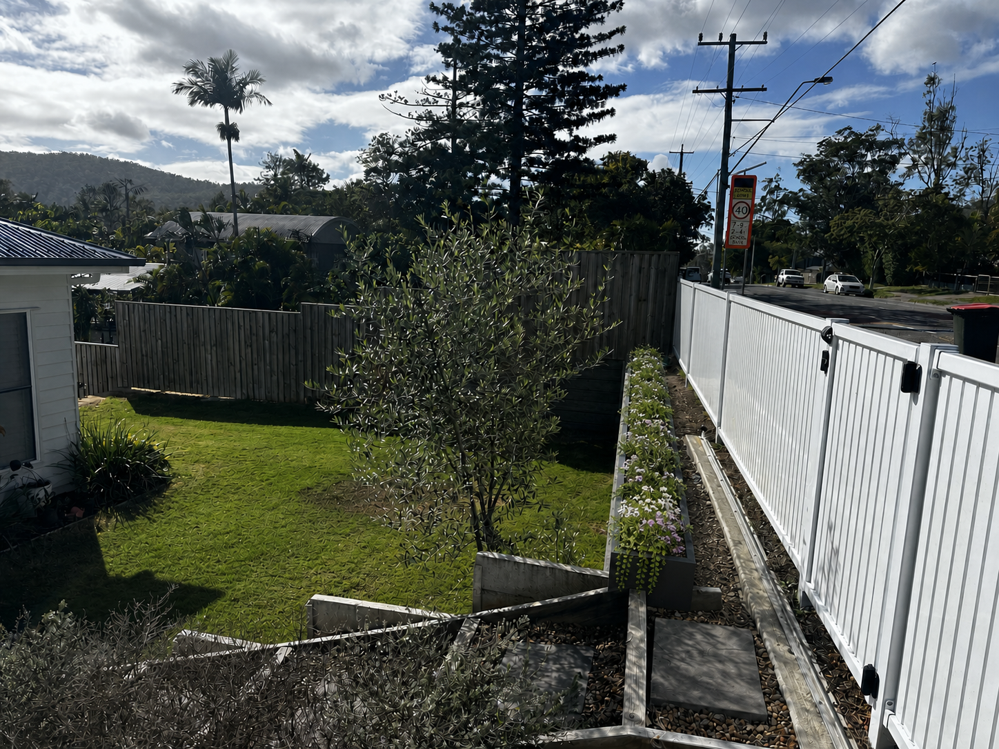 Final slim charcoal raised planting channel on lawn-facing ledge with track and steps clear